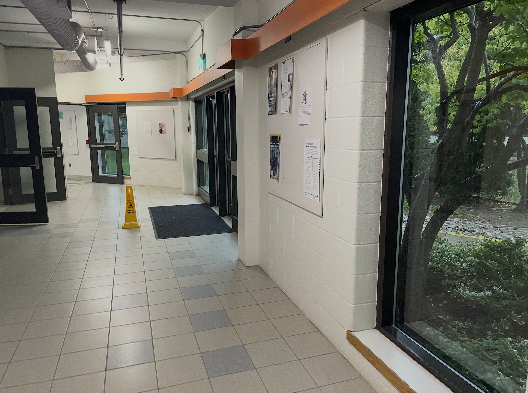 This is the entrance to the E wing. There is some color such as the orange stripe which can depict energy and excitement influencing a students feelings. There are also windows that can let natural light in and can let students see the nature outside giving positive energy. The walls are made of brick but the way they are painted makes it appear more friendly. <div class='container'><iframe class='responsive-iframe' src='https://www.youtube.com/embed/tgbNymZ7vqY'></iframe></div>